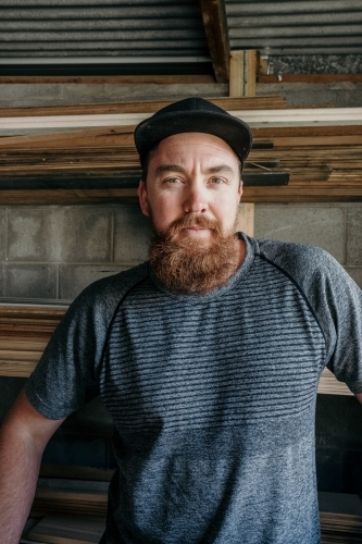 Man with long moustache standing in his timber workshop. - Australian Stock Image