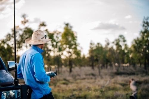 Man with remote control looking into distance - Australian Stock Image