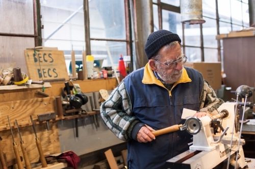 Man working on a lathe in a men's shed