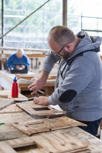 Man working on a project at a men's shed - Australian Stock Image