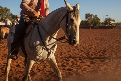 Mans riding horse in outback cattle yard - Australian Stock Image
