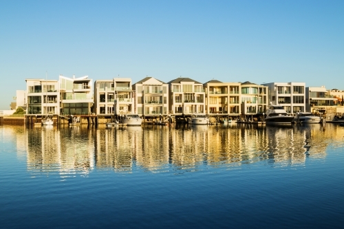 Marina homes reflecting in the water in morning light
