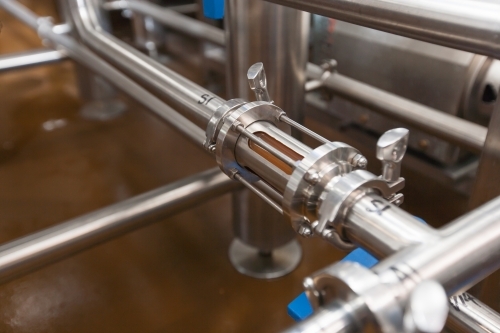 Mash running through stainless steel tube at a microbrewery