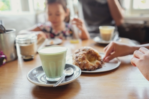 Matcha green tea latte with family background - Australian Stock Image