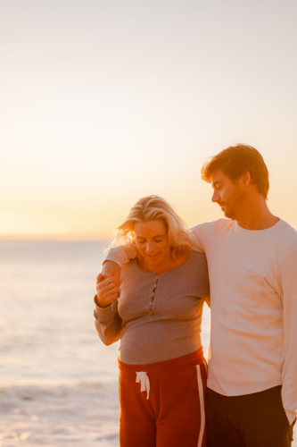 Maternity couple embracing at Manly Beach during sunrise - Australian Stock Image