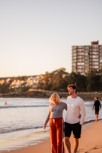 Maternity couple walking at Manly Beach during sunrise in Australia - Australian Stock Image