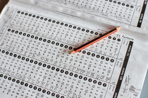 Maths workbook on table in classroom with pencil - Australian Stock Image
