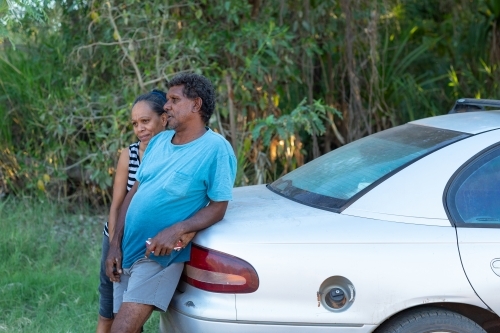 mature couple leaning against car boot