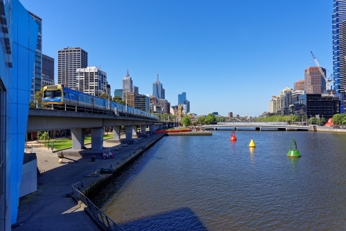 Melbourne Yarra river with oncoming train overlooking city views - Australian Stock Image
