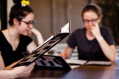 Menu at pub with blurred females in background - Australian Stock Image