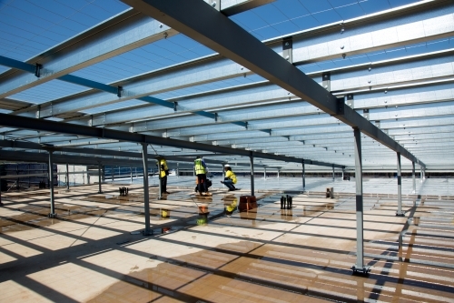 Metal framework and workers on an industrial building site - Australian Stock Image