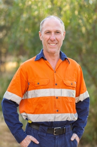Middle aged man in high vis workwear smiling portrait outside - Australian Stock Image