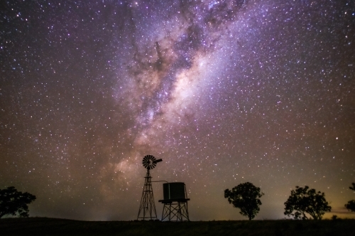 Milky Way setting behind a windmill and water tank on a clear night. - Australian Stock Image