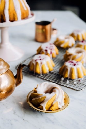 Mini iced bundt cakes on baking rack - Australian Stock Image