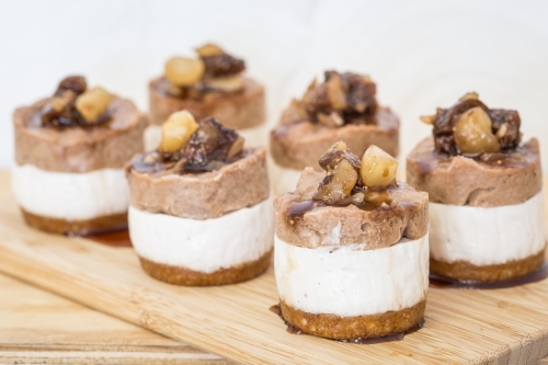 Mini raw Macadamia, choc cheesecakes served on a board - Australian Stock Image