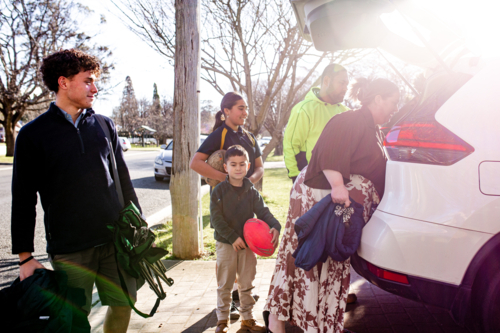 Mixed ethnicity family unpacking car boot - Australian Stock Image