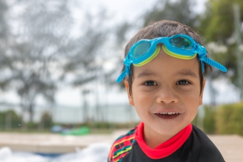 Mixed race boy playing in small backyard pool - Australian Stock Image