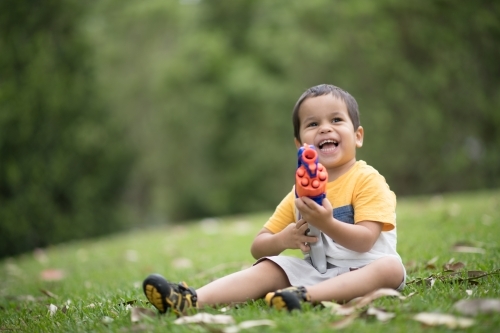 Mixed race boys playing outside with Nerf dart guns - Australian Stock Image
