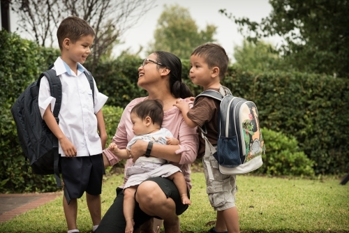 Mixed race boys say good-bye to their mum on their first day of school - Australian Stock Image