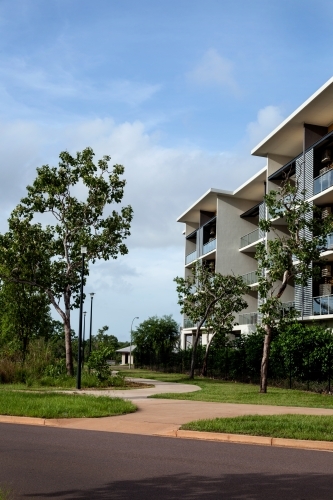 Modern apartment building with green space and blue skies - Australian Stock Image