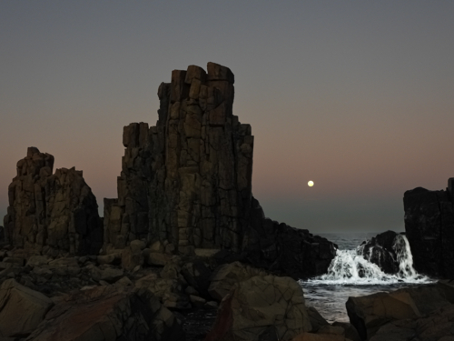 moonscape at bombo with coastal rocks in foreground - Australian Stock Image