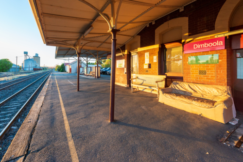 Morning light on Dimboola railway station platform with old benches and tracks - Australian Stock Image
