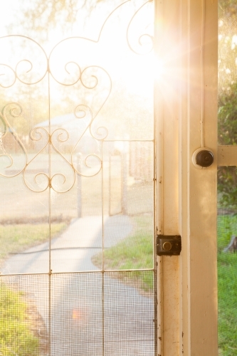 Morning sun flare through screen door of country homestead house - Australian Stock Image