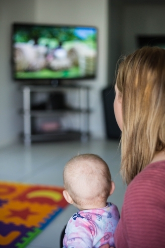 Mother and child sitting watching television - Australian Stock Image