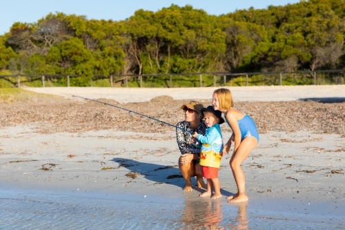 mother and children fishing on the beach - Australian Stock Image