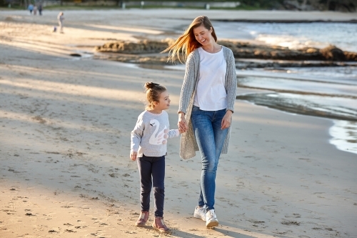 Mother and daughter at beach on sunset - Australian Stock Image
