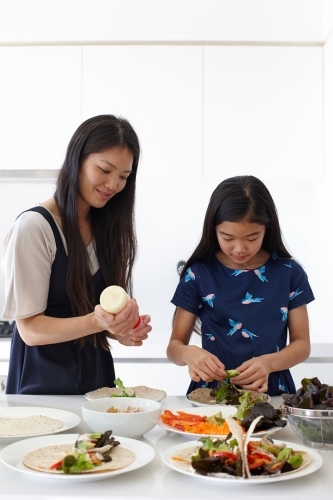 Mother and daughter in kitchen cooking together