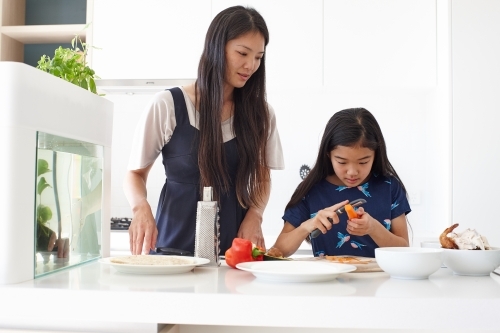 Mother and daughter in kitchen together preparing lunch