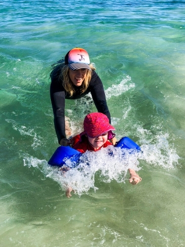 Mother and daughter playing in the ocean together - Australian Stock Image