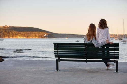 Mother and daughter sharing time laughing at beach promenade - Australian Stock Image