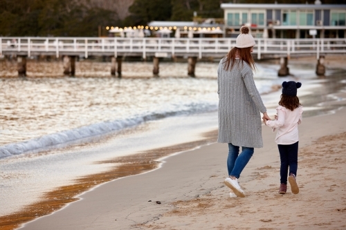 Mother and daughter sharing time laughing at beach promenade