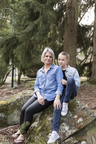 Mother and daughter sitting on a rock - Australian Stock Image