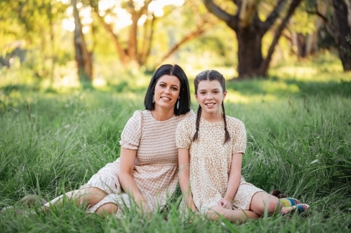 Mother and daughter sitting together in natural Australian bush setting - Australian Stock Image