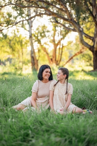 Mother and daughter sitting together in natural Australian bush setting - Australian Stock Image