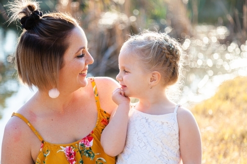 Mother and daughter smiling together outside - Australian Stock Image