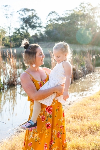 Mother and daughter smiling together outside - Australian Stock Image