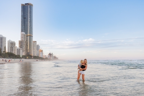 Mother and son playing in shallow water on Main Beach, Surfers Paradise on the Gold Coast - Australian Stock Image