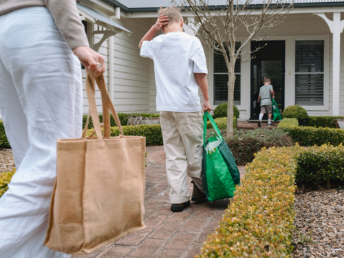 Mother and son walking on a brick pathway towards the house - Australian Stock Image