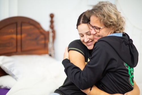 Mother and teen daughter hugging - Australian Stock Image