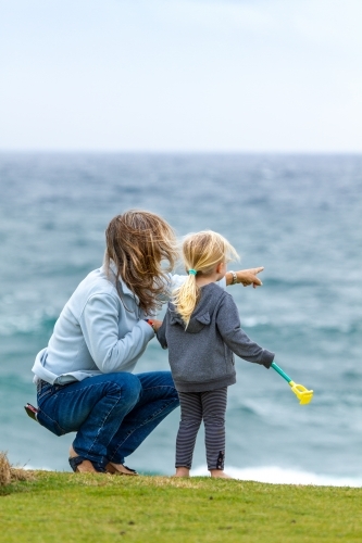 Mother and young girl looking out to see.