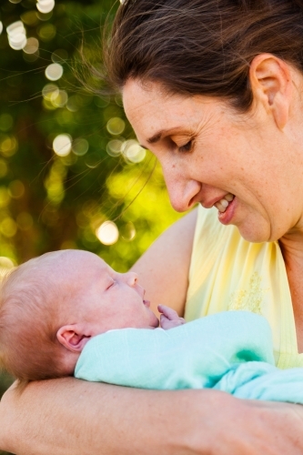 Mother bonding with her newborn daughter outside showing love - Australian Stock Image