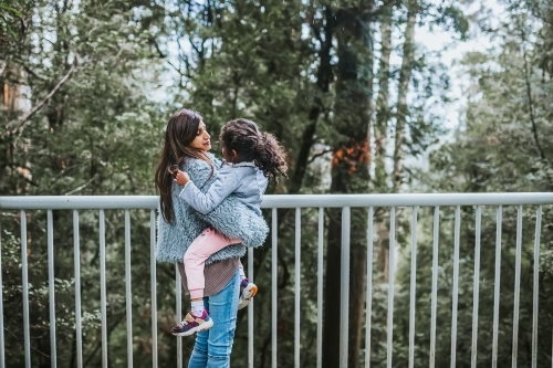 mother carrying daughter - Australian Stock Image