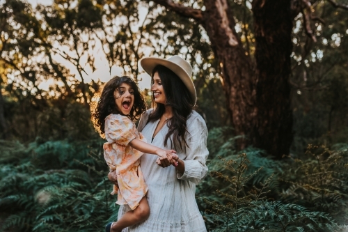 Mother carrying the daughter in the park