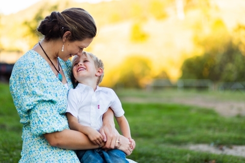 Mother hugging young son outside - Australian Stock Image