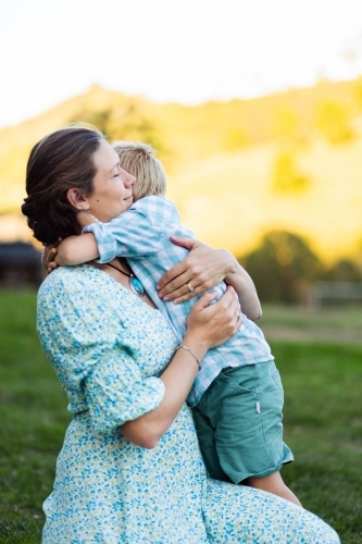 Mother hugging young son outside - Australian Stock Image
