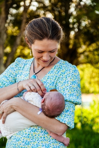 Mother looking at her newborn daughter smiling outside